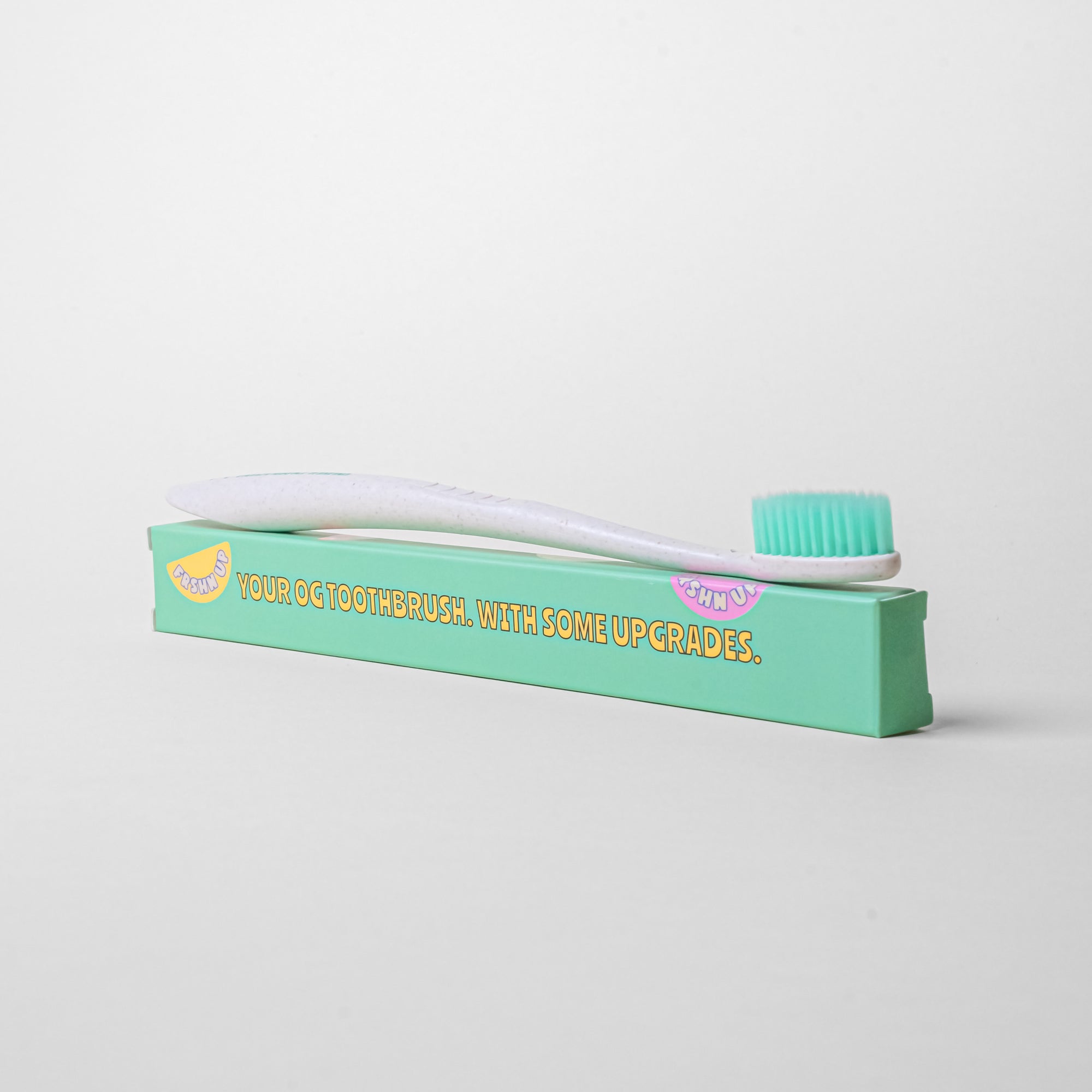 An OG Toothbrush in a box by FRSHN UP on a white surface.