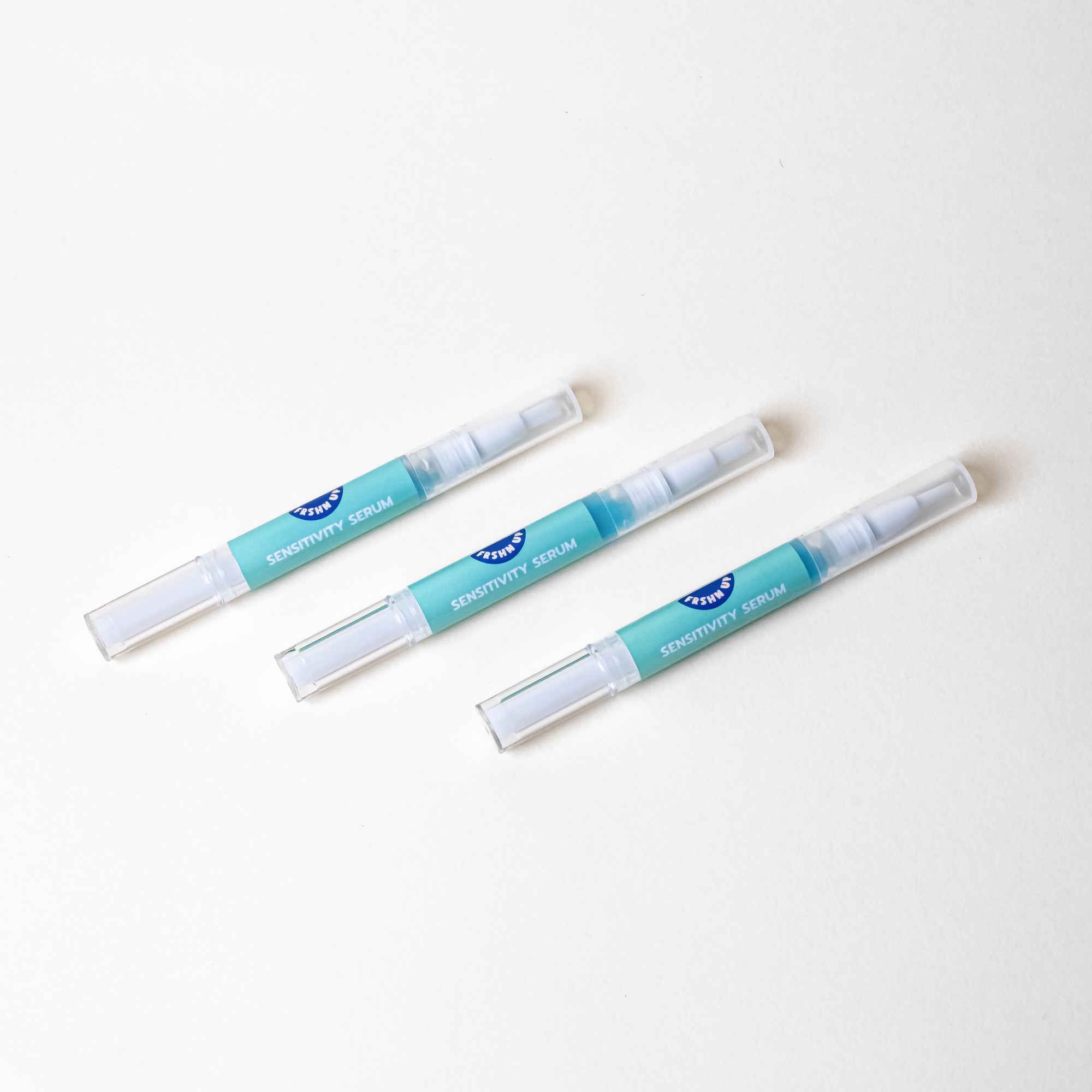 Three FRSHN UP Sensitivity Serum pens on a white surface.